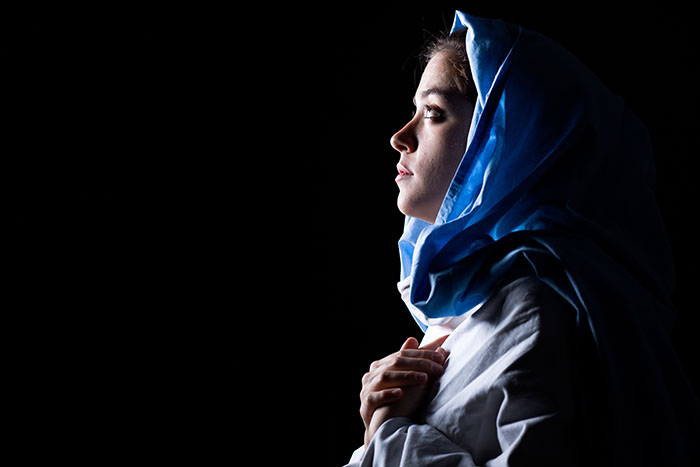 Virgin Mary with Blue Veil Praying on Black Background